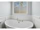Elegant soaking tub situated under a window with decorative privacy screen at 2046 Fellini Dr, Apex, NC 27502