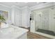 Modern bathroom with marble counters, wood look tile flooring, and a walk in shower with glass door at 2046 Fellini Dr, Apex, NC 27502