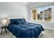 Inviting bedroom with a comfortable bed, plush blue bedding, and a large window with neighborhood view at 2046 Fellini Dr, Apex, NC 27502