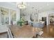 Open-concept dining area connected to the kitchen, features a wooden table, and stylish chandelier at 2046 Fellini Dr, Apex, NC 27502