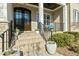 Inviting front porch with brick steps, black iron railings, and comfortable seating area with blue cushions at 2046 Fellini Dr, Apex, NC 27502