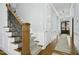 Bright hallway featuring hardwood floors, elegant staircase, and decorative lighting fixtures at 2046 Fellini Dr, Apex, NC 27502