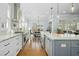 Spacious kitchen featuring white cabinets, stainless appliances, and a large island with pendant lighting at 2046 Fellini Dr, Apex, NC 27502