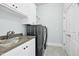Convenient laundry room with sink, storage, counter space, and modern washer and dryer at 2046 Fellini Dr, Apex, NC 27502