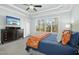 This main bedroom features tray ceilings, a TV, and a large window providing ample natural light at 2046 Fellini Dr, Apex, NC 27502