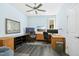 Bright office features wood flooring, multiple monitors, ceiling fan and natural light at 2046 Fellini Dr, Apex, NC 27502