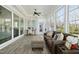 Bright sunroom with ample windows, wood-look floors, and a comfortable seating area plus an office work space at 2046 Fellini Dr, Apex, NC 27502