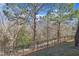 Fenced backyard featuring walking trail access and views of the surrounding wooded area at 205 Virginia Water Dr, Rolesville, NC 27571
