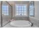 Bright bathroom features soaking tub beneath a window, complemented by a sleek glass-enclosed shower at 205 Virginia Water Dr, Rolesville, NC 27571