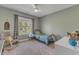 Neutral-colored bedroom featuring a single bed, rocking chair and large window at 205 Virginia Water Dr, Rolesville, NC 27571