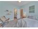 Light blue bedroom with attached bathroom, chair, and a white bed at 205 Virginia Water Dr, Rolesville, NC 27571