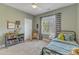 Olive-green bedroom with a single bed, playful decor, and bright natural light at 205 Virginia Water Dr, Rolesville, NC 27571