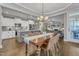 Dining area showcases hardwood floors, an elegant chandelier, and an open view of the kitchen and living room at 205 Virginia Water Dr, Rolesville, NC 27571