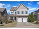 Charming two-story home featuring a two-car garage and landscaped front yard on a sunny day at 205 Virginia Water Dr, Rolesville, NC 27571