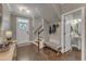 Welcoming foyer with hardwood floors, staircase, hall tree and a view into the powder room at 205 Virginia Water Dr, Rolesville, NC 27571