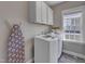 Bright laundry room featuring white washer/dryer, white cabinets, and natural light from the window at 205 Virginia Water Dr, Rolesville, NC 27571