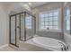 Modern main bathroom featuring a soaking tub, a separate glass shower, and a large window at 205 Virginia Water Dr, Rolesville, NC 27571