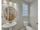 Charming powder room featuring a pedestal sink, round mirror, and neutral wall color at 205 Virginia Water Dr, Rolesville, NC 27571