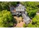 An aerial view of a well-maintained home featuring mature trees, a brick driveway, and a complex roofline at 2140 N Lakeshore Dr, Chapel Hill, NC 27514