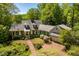 Beautiful aerial view of a home with lush landscaping, brick driveway, and mature trees at 2140 N Lakeshore Dr, Chapel Hill, NC 27514