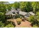 Stunning aerial shot of home with lush landscaping, brick driveway, and lake views at 2140 N Lakeshore Dr, Chapel Hill, NC 27514