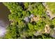 An aerial view of a lakeside home surrounded by lush trees, featuring a private dock, and sprawling grounds at 2140 N Lakeshore Dr, Chapel Hill, NC 27514