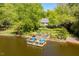 Aerial view of home and lake with a lake gazebo and dock for enjoying lake living at 2140 N Lakeshore Dr, Chapel Hill, NC 27514