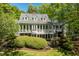 Back of the house featuring a sunroom with large windows, a private balcony, and manicured landscaping at 2140 N Lakeshore Dr, Chapel Hill, NC 27514