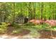 Idyllic backyard featuring a storage shed, lush foliage, and landscaped areas at 2140 N Lakeshore Dr, Chapel Hill, NC 27514