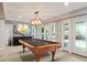 Finished basement showcasing a pool table with unique lighting and access to outdoor patio at 2140 N Lakeshore Dr, Chapel Hill, NC 27514