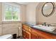 Charming bathroom featuring beautiful wooden vanity, sink, and bright light from the window at 2140 N Lakeshore Dr, Chapel Hill, NC 27514