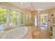 Bright bathroom featuring a bathtub, glass walk-in shower, and multiple windows at 2140 N Lakeshore Dr, Chapel Hill, NC 27514