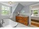 Bathroom featuring a clawfoot tub, vintage wooden vanity with sink, and natural light from window at 2140 N Lakeshore Dr, Chapel Hill, NC 27514