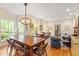 Dining and living area with wood floors, paneled walls, large windows, and an adjoining kitchen at 2140 N Lakeshore Dr, Chapel Hill, NC 27514