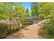 Picturesque driveway leading to a beautiful home surrounded by mature trees and colorful landscaping at 2140 N Lakeshore Dr, Chapel Hill, NC 27514
