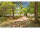 Long, winding brick driveway leading to a home nestled among trees, offering privacy and charm at 2140 N Lakeshore Dr, Chapel Hill, NC 27514