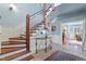 Light-filled foyer featuring wood staircase, tile floors,paneled walls, decor table, and an arched doorway at 2140 N Lakeshore Dr, Chapel Hill, NC 27514