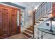 Inviting foyer with beautiful hardwood floors, grand staircase, and stunning wood door at 2140 N Lakeshore Dr, Chapel Hill, NC 27514