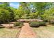 Lush front yard features a brick path, manicured bushes and flowers at 2140 N Lakeshore Dr, Chapel Hill, NC 27514