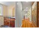Hallway view, featuring a bathroom vanity, wood floors, neutral walls, and decorative artwork at 2140 N Lakeshore Dr, Chapel Hill, NC 27514