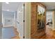 Hallway features hardwood floors, white doors, brick accent wall and adjacent shelving and bedroom view at 2140 N Lakeshore Dr, Chapel Hill, NC 27514