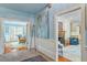 Hallway with light blue walls, white trim, and hardwood flooring that leads to multiple living spaces at 2140 N Lakeshore Dr, Chapel Hill, NC 27514