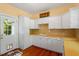 Bright kitchen with white cabinets, warm-toned countertops, and access to the outdoors at 2140 N Lakeshore Dr, Chapel Hill, NC 27514