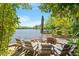 Beautiful lakeside patio with chairs and a fire pit, perfect for relaxing and enjoying the view at 2140 N Lakeshore Dr, Chapel Hill, NC 27514