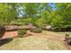 Beautifully landscaped front yard with brick walkways, mature trees, and vibrant flowering shrubs at 2140 N Lakeshore Dr, Chapel Hill, NC 27514