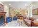 Comfortable living room flowing into the kitchen, featuring a fireplace and stylish blue armchairs at 2140 N Lakeshore Dr, Chapel Hill, NC 27514