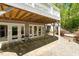 A stone patio features ample shade with covered deck above and direct access to the interior via multiple french doors at 2140 N Lakeshore Dr, Chapel Hill, NC 27514