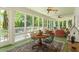 Bright sunroom with glass windows, cozy seating, and a ceiling fan for comfort at 2140 N Lakeshore Dr, Chapel Hill, NC 27514