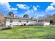 Spacious backyard featuring a deck, screened porch, grassy lawn, and mature trees, perfect for outdoor living and entertaining at 2246 Arrowhead Rd, Dunn, NC 28334