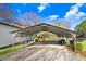 Long carport with gravel driveway, greenery, and natural light at 2246 Arrowhead Rd, Dunn, NC 28334